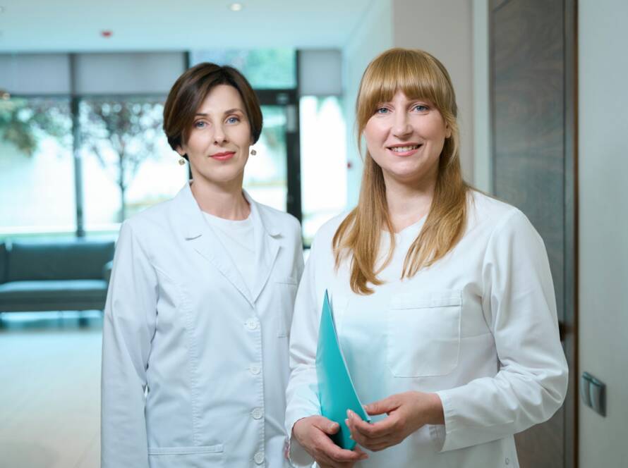 Female doctors stand in the hospital foyer at reception desk