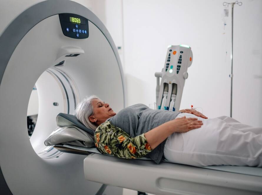 Radiology patient on CT scan machine bed in diagnostic center.